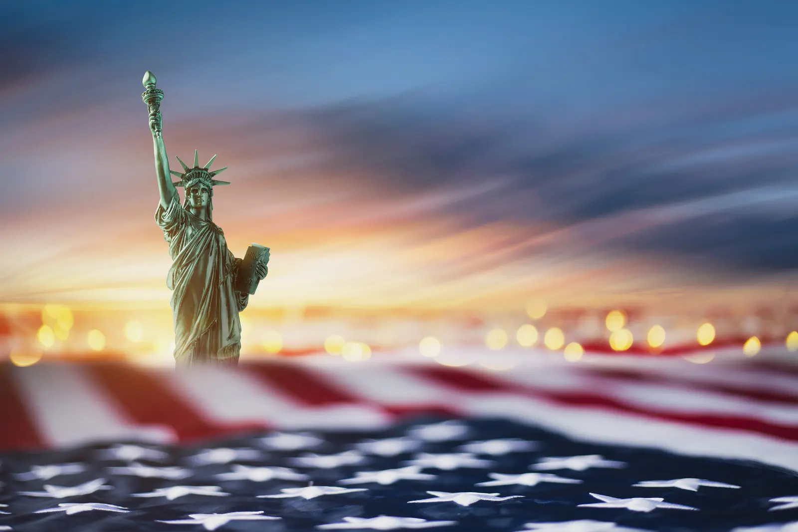 Estátua da Liberdade ao amanhecer sobre a bandeira dos Estados Unidos